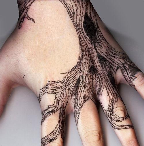 Gnarly tree tattoo on someones hand.