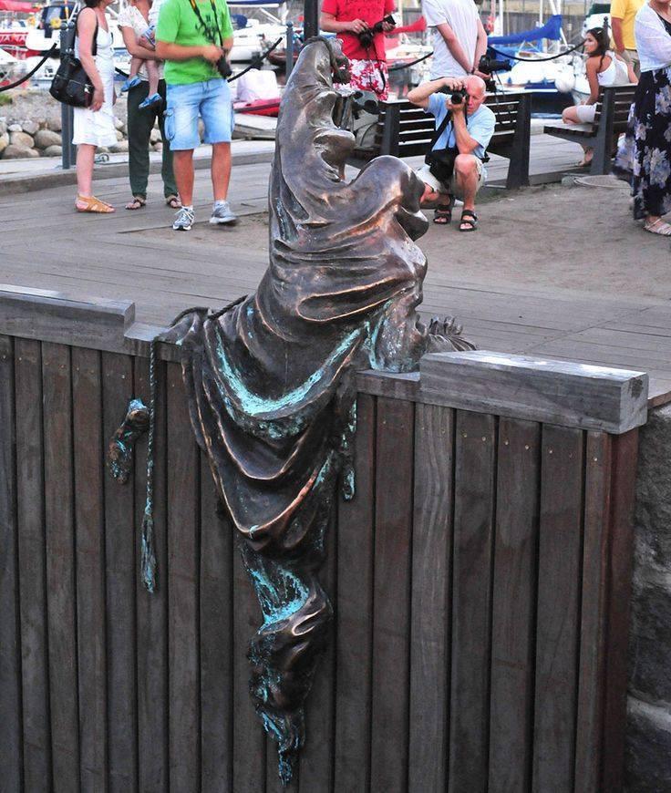 Men jumping on the wall statue